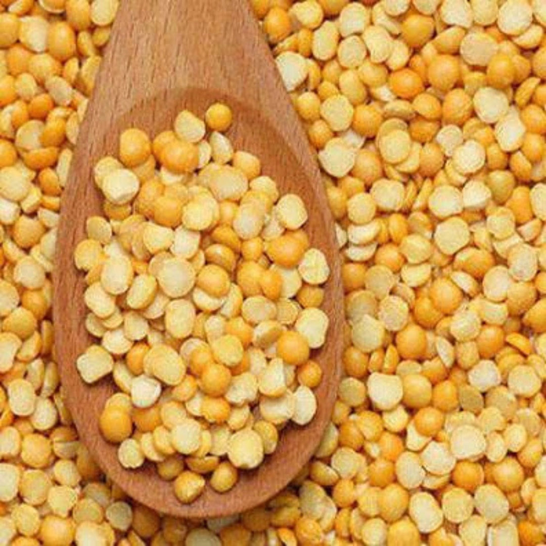 Organic chana dal online displayed in a wooden spoon over a background of yellow dal