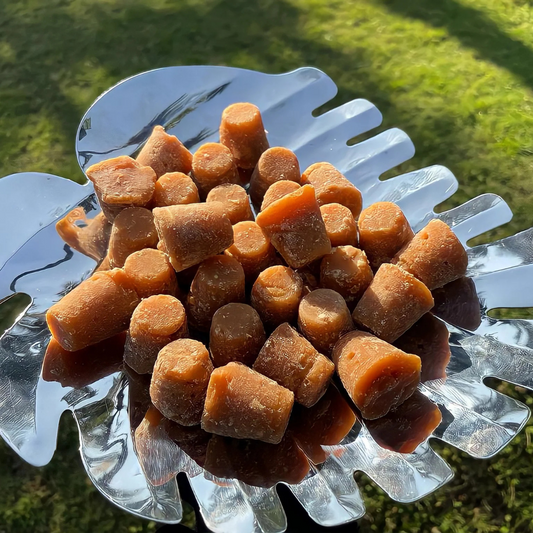 My Store organic jaggery cubes displayed on a metallic leaf-shaped platter outdoors