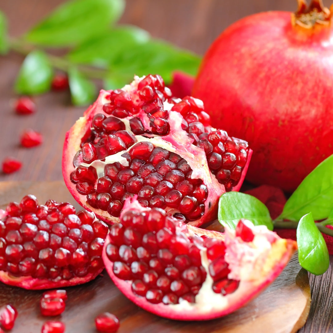 Fresh organic pomegranate online Mumbai with juicy red seeds and vibrant skin on a wooden surface