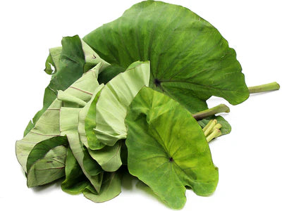 Fresh organic taro leaves piled together, showcasing their vibrant green color and unique shape