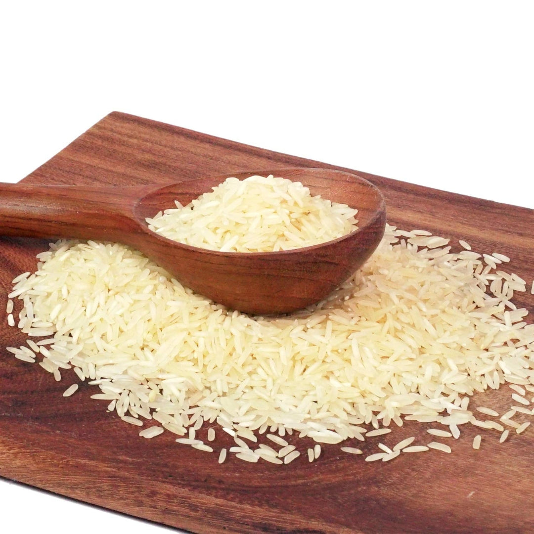 Organic basmati rice in a wooden spoon on a cutting board for cooking and meal prep