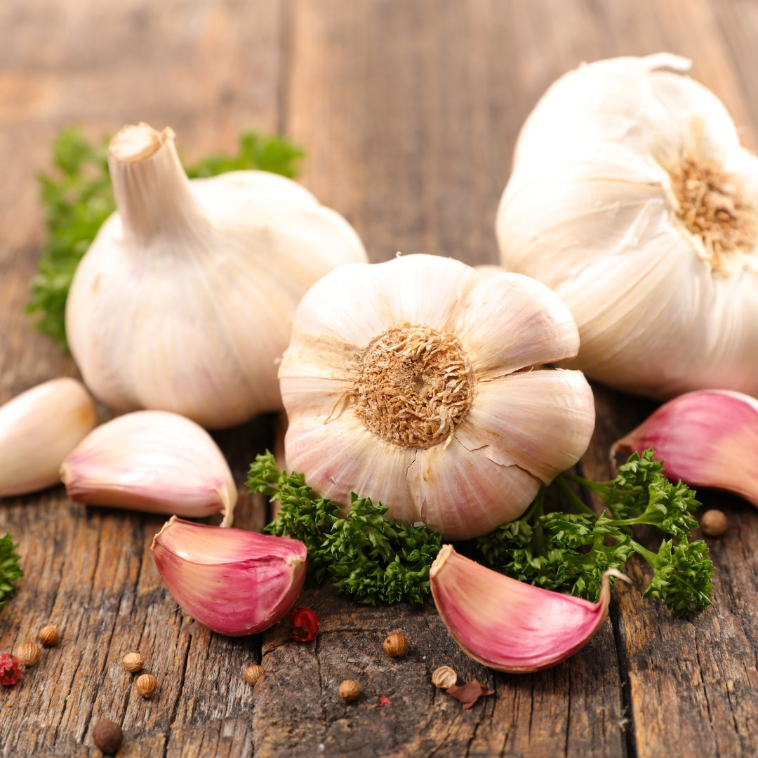 Fresh organic garlic online with whole bulbs and cloves on a rustic wooden surface