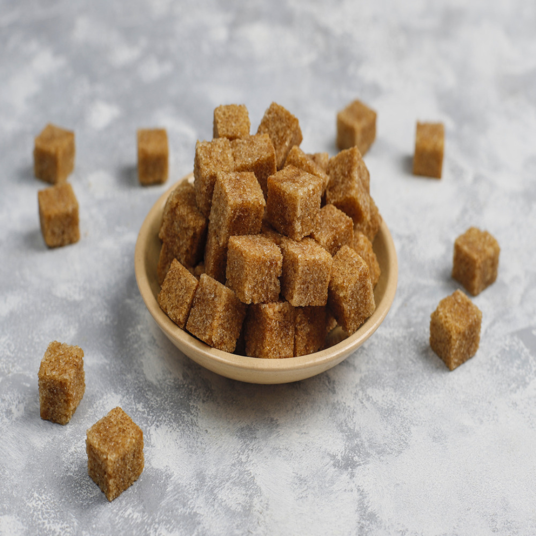 Bowl of organic jaggery cubes on a textured surface, healthy sweetener for recipes