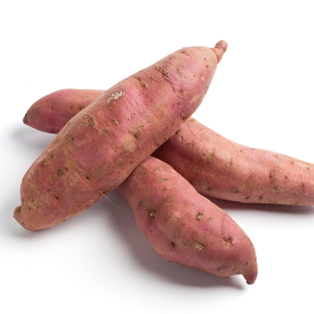 Fresh organic sweet potato pile showcasing vibrant pink skin and smooth texture